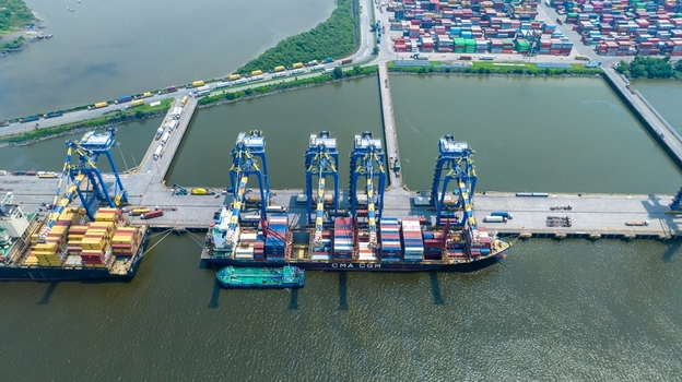 Aerial view of Jawaharlal Nehru Port Authority with a container ship docked at the terminal featuring gantry cranes and colorful shipping containers Juna Sheva Maharashtra India. Aerial view of Jawaharlal Nehru Port Authority with a container ship docked at the terminal featuring gantry cranes and colorful shipping containers Juna Sheva Maharashtra India.