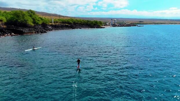 Aerial view of a hydrofoil and one man outrigger canoe in blue water United States. Aerial view of a hydrofoil and one man outrigger canoe in blue water United States.