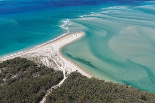 Aerial view of Moreton Island showing the white sand spit turquoise shallow waters sandbars and dense coastal vegetation in Kooringal Queensland Australia. Aerial view of Moreton Island showing the white sand spit turquoise shallow waters sandbars and dense coastal vegetation in Kooringal Queensland Australia.