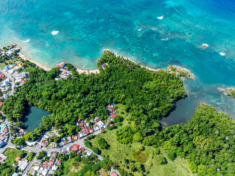 Aerial view of Rio San Juan featuring lush vegetation a lagoon houses with red rooftops and turquoise Caribbean waters in Rio San Juan Maria Trinidad Sanchez Dominican Republic. Aerial view of Rio San Juan featuring lush vegetation a lagoon houses with red rooftops and turquoise Caribbean waters in Rio San Juan Maria Trinidad Sanchez Dominican Republic.