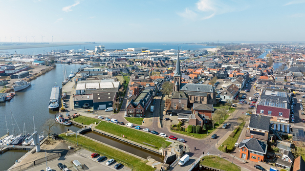 Aerial view of the historic town of Lemmer with its canal harbor church and traditional Dutch architecture under a clear blue sky in Lemmer Friesland Netherlands. Aerial view of the historic town of Lemmer with its canal harbor church and traditional Dutch architecture under a clear blue sky in Lemmer Friesland Netherlands.