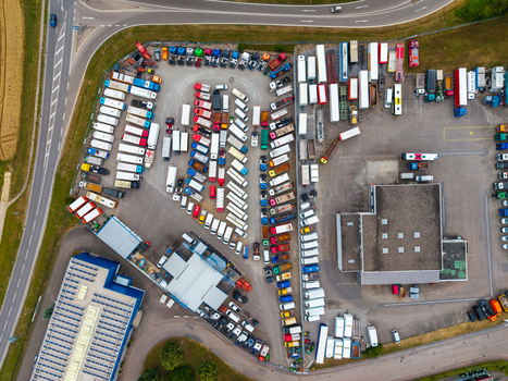 Aerial view of the Neuenstein Techno Zone logistics center with rows of parked semi trucks trailers and industrial warehouse buildings in Neuenstein Baden Wurttemberg Germany. Aerial view of the Neuenstein Techno Zone logistics center with rows of parked semi trucks trailers and industrial warehouse buildings in Neuenstein Baden Wurttemberg Germany.