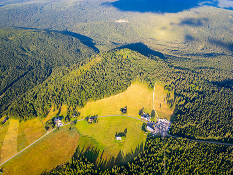 Aerial view of Jizerka village nestled in the lush green meadows and dense coniferous forests of the Jizera Mountains in Korenov Liberec Region Czechia. Aerial view of Jizerka village nestled in the lush green meadows and dense coniferous forests of the Jizera Mountains in Korenov Liberec Region Czechia.