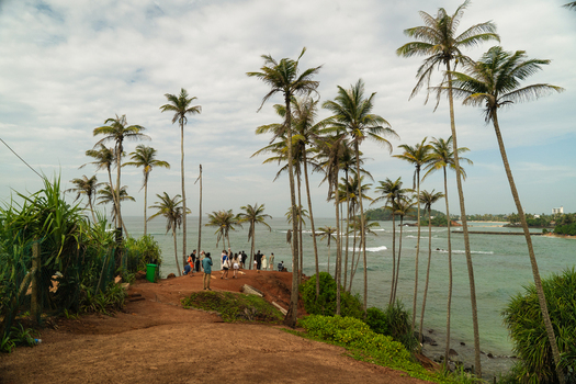 View of Coconut Tree Hill with tall palm trees and tourists overlooking the Indian Ocean in Mirissa Southern Province Sri Lanka. View of Coconut Tree Hill with tall palm trees and tourists overlooking the Indian Ocean in Mirissa Southern Province Sri Lanka.