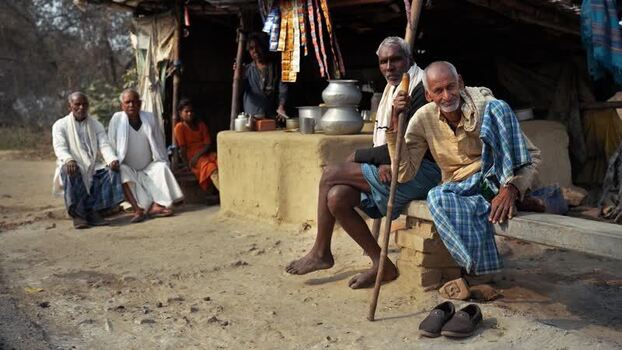 View of elderly men sitting outside a roadside stall India.