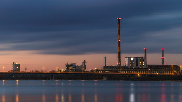 View of Zeran Power Plant with tall chimneys and a bridge over the Vistula river at dusk in Warsaw Mazowieckie Poland. View of Zeran Power Plant with tall chimneys and a bridge over the Vistula river at dusk in Warsaw Mazowieckie Poland.