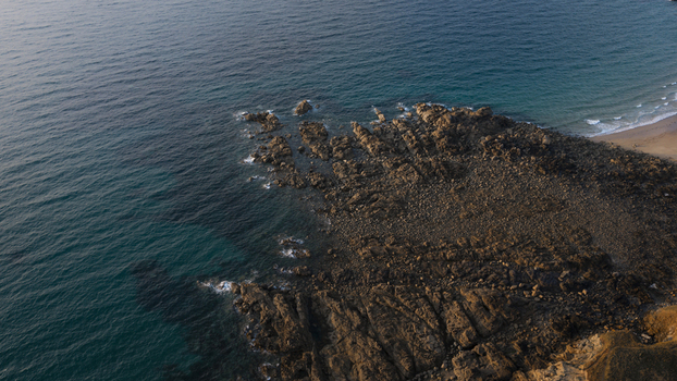 Aerial view of the rugged coastline with rocky outcrops turquoise ocean waters and sandy beach in Plevenon Brittany France. Aerial view of the rugged coastline with rocky outcrops turquoise ocean waters and sandy beach in Plevenon Brittany France.