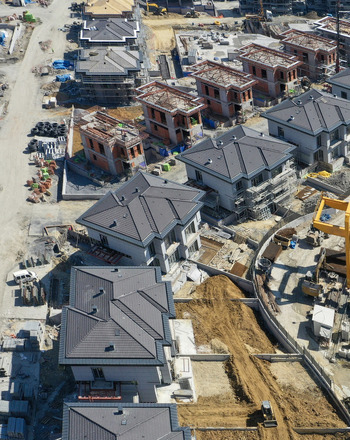 Aerial view of a modern residential construction site with villas featuring grey rooftops and brick walls under development in Avcilar Istanbul Turkiye. Aerial view of a modern residential construction site with villas featuring grey rooftops and brick walls under development in Avcilar Istanbul Turkiye.