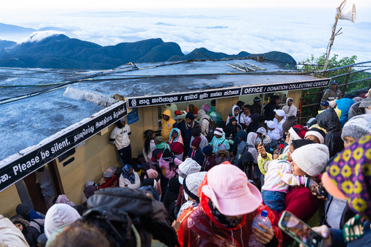 Ratnapura Sri Lanka 23 February 2026 View of pilgrims and tourists gathered at the summit of Adam s Peak near the donation center above a sea of clouds.
