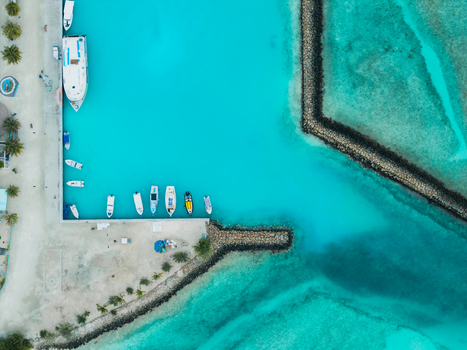 Aerial view of boats resting in the marina with turquoise waters and white sandy beaches creating a striking contrast Vashafaru Island Maldives. Aerial view of boats resting in the marina with turquoise waters and white sandy beaches creating a striking contrast Vashafaru Island Maldives.