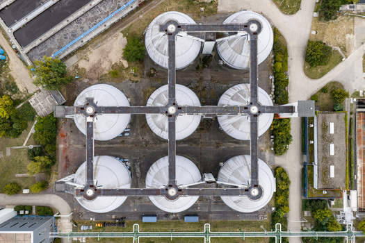 Aerial view of Klarwerk Ruhleben sewage treatment plant with its distinctive grid of large circular digester tanks and connecting walkways in Berlin Berlin Germany.