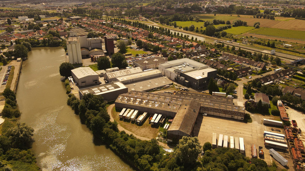 Aerial view of industrial facilities and warehouses situated along a canal in Saint Omer Hauts de France France. Aerial view of industrial facilities and warehouses situated along a canal in Saint Omer Hauts de France France.