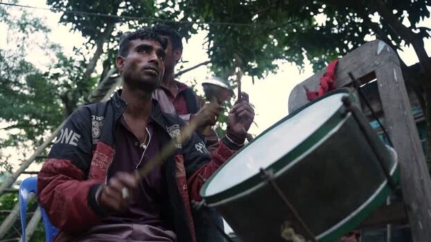 View of a man playing a traditional drum in Bogura Bangladesh. View of a man playing a traditional drum in Bogura Bangladesh.