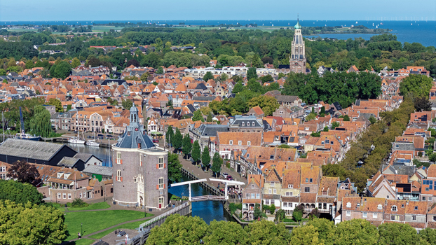 Aerial view of the historic town of Enkhuizen featuring the Drommedaris tower traditional Dutch rooftops canals and a church spire in Enkhuizen North Holland Netherlands. Aerial view of the historic town of Enkhuizen featuring the Drommedaris tower traditional Dutch rooftops canals and a church spire in Enkhuizen North Holland Netherlands.
