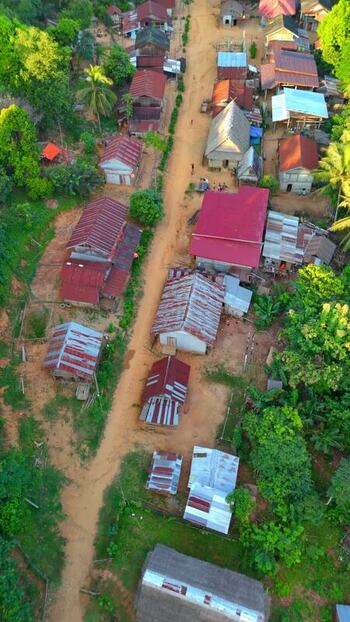 Aerial view of the village houses and dirt road in Muang Ngoy Laos.