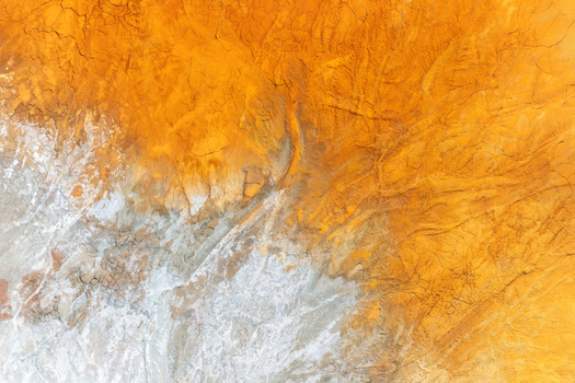 Aerial view of the vibrant orange iron rich soil and cracked earth textures at the historic mining site Minas de Riotinto Andalusia Spain.