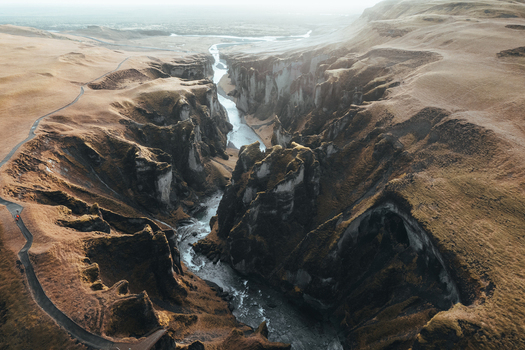 Aerial view of the sinuous Fjadrargljufur canyon carved by the Fjadra River with its steep cliffs and winding waterway Fjadrargljufur Iceland. Aerial view of the sinuous Fjadrargljufur canyon carved by the Fjadra River with its steep cliffs and winding waterway Fjadrargljufur Iceland.