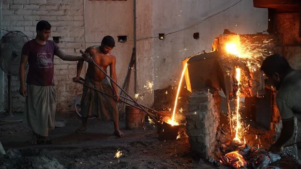 View of workers pouring molten metal in a foundry in Bangladesh.