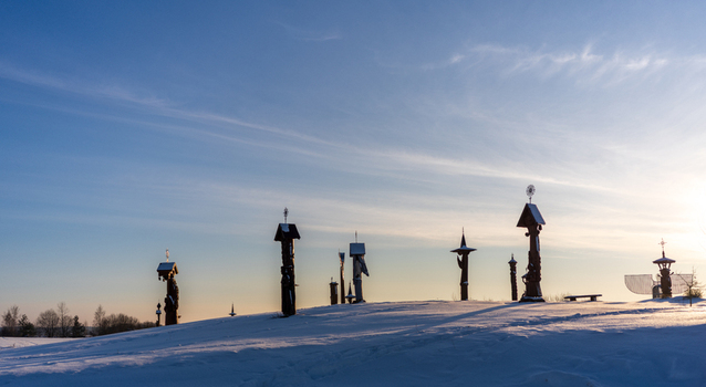 View of traditional wooden crosses and sculptures on a snow covered hill during sunset in Trakai Vilnius County Lithuania. View of traditional wooden crosses and sculptures on a snow covered hill during sunset in Trakai Vilnius County Lithuania.