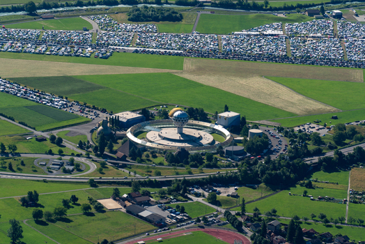 View of Jungfrau Park with its distinctive circular architecture and central dome surrounded by green fields and parking areas in Unterseen Canton of Bern Switzerland.