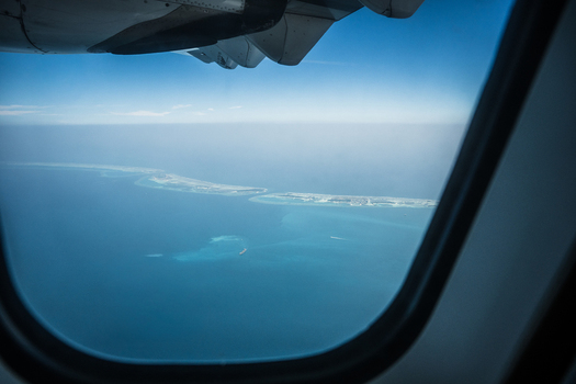 Aerial view of the islands surrounded by the vast deep blue ocean seen from an airplane window Flight from Male to Hanimaadhoo island Maldives.