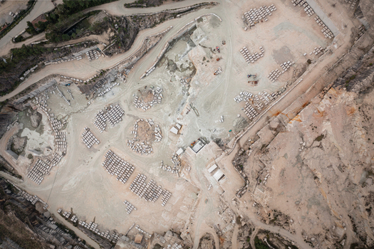 Aerial view of Cantera Porrino a large granite quarry with organized blocks of stone excavation pits and dusty access roads in O Porrino Pontevedra Spain. Aerial view of Cantera Porrino a large granite quarry with organized blocks of stone excavation pits and dusty access roads in O Porrino Pontevedra Spain.