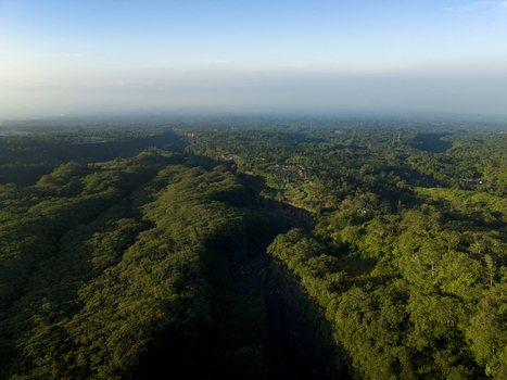 Aerial view of Bunker Kaliadem Merapi surrounded by dense tropical forest and a deep volcanic ravine under a clear sky Kecamatan Pakem Daerah Istimewa Yogya Indonesia. Aerial view of Bunker Kaliadem Merapi surrounded by dense tropical forest and a deep volcanic ravine under a clear sky Kecamatan Pakem Daerah Istimewa Yogya Indonesia.