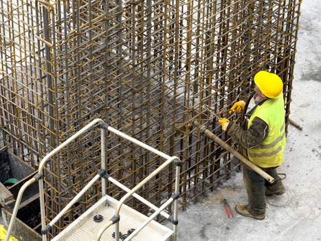 View of a construction worker in a yellow hard hat and safety vest working on a steel rebar structure at a building site in Avcilar Istanbul Turkiye. View of a construction worker in a yellow hard hat and safety vest working on a steel rebar structure at a building site in Avcilar Istanbul Turkiye.