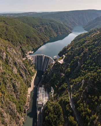 Aerial view of Encoro de Santo Estevo dam situated in a deep canyon surrounded by lush green forests and the Sil River in Ourense Ourense Spain. Aerial view of Encoro de Santo Estevo dam situated in a deep canyon surrounded by lush green forests and the Sil River in Ourense Ourense Spain.
