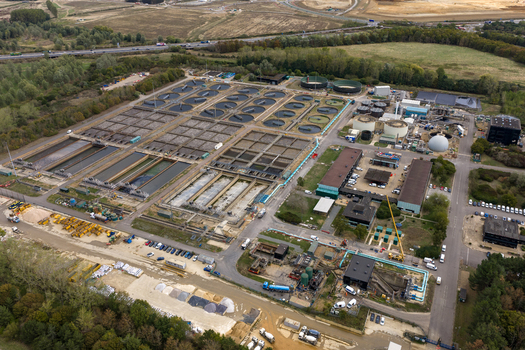 Aerial view of the water treatment plant featuring circular sedimentation tanks and rectangular aeration basins surrounded by green fields in Broughton England United Kingdom. Aerial view of the water treatment plant featuring circular sedimentation tanks and rectangular aeration basins surrounded by green fields in Broughton England United Kingdom.