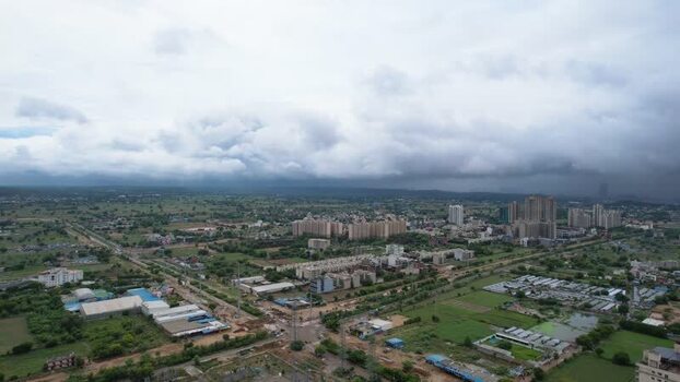 Aerial view of Gurugram cityscape under monsoon clouds India.
