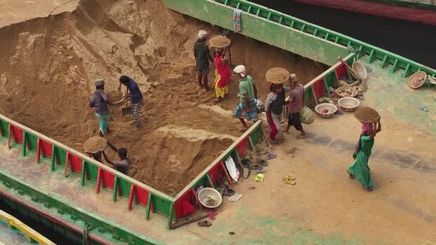 Aerial view of workers unloading sand from a barge in Bangladesh. Aerial view of workers unloading sand from a barge in Bangladesh.