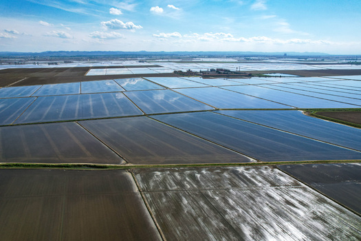 Aerial view of Azienda Agricola Veneria with flooded rice fields reflecting the blue sky and clouds in Veneria Piemonte Italy. Aerial view of Azienda Agricola Veneria with flooded rice fields reflecting the blue sky and clouds in Veneria Piemonte Italy.