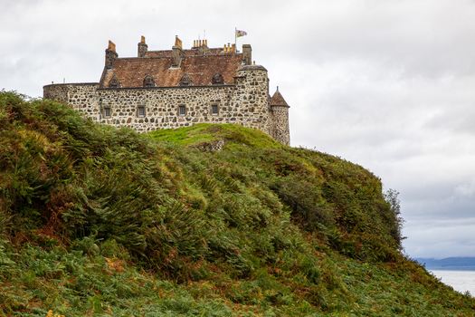 View of Duart Castle standing on a green hill covered in ferns under a cloudy sky in Isle of Mull Scotland United Kingdom.