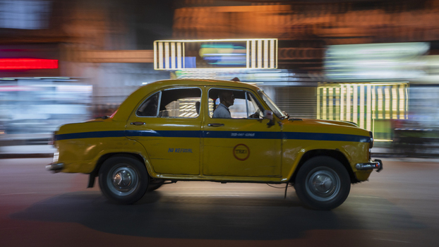 Kolkata India 05 December 2024 View of a classic yellow taxi streaks through the vibrant blurred lights of the city embodying the dynamic pulse of Kolkata. Kolkata India 05 December 2024 View of a classic yellow taxi streaks through the vibrant blurred lights of the city embodying the dynamic pulse of Kolkata.