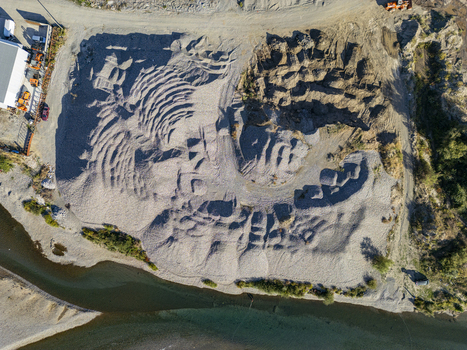 Aerial view of Rruga Katalines showing large piles of gravel and sand extraction patterns near the riverbank in Bahcallek Shkoder County Albania.