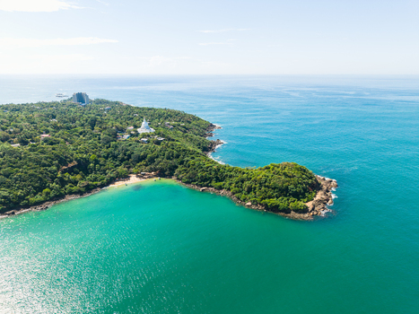 Aerial view of Jungle Beach and the Japanese Peace Pagoda surrounded by lush tropical forest and turquoise ocean water in Unawatuna Sri Lanka. Aerial view of Jungle Beach and the Japanese Peace Pagoda surrounded by lush tropical forest and turquoise ocean water in Unawatuna Sri Lanka.