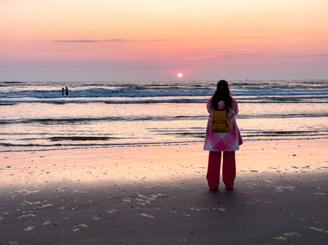Wijk aan Zee Netherlands 06 June 2024 View of a person with a yellow backpack standing on Strand Wijk aan Zee watching the sunset over the North Sea with pink and orange sky. Wijk aan Zee Netherlands 06 June 2024 View of a person with a yellow backpack standing on Strand Wijk aan Zee watching the sunset over the North Sea with pink and orange sky.