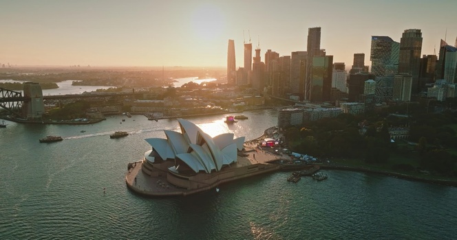 Aerial view of Sydney Opera House situated on the harbour with the city skyline in the background during golden hour in Sydney New South Wales Australia. Aerial view of Sydney Opera House situated on the harbour with the city skyline in the background during golden hour in Sydney New South Wales Australia.