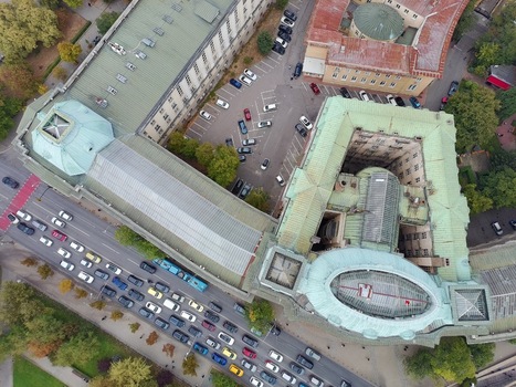 Aerial view of Sofia University St. Kliment Ohridski featuring green copper roofs historic architecture a parking lot and busy traffic in Sofia Sofia City Province Bulgaria.