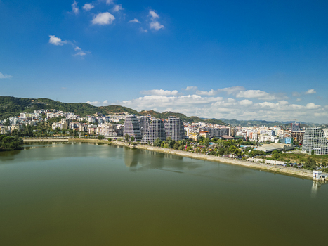 Aerial view of Lake View Residences situated along the artificial lake featuring modern architectural towers surrounding greenery and urban cityscape in Tirane Tirana County Albania.