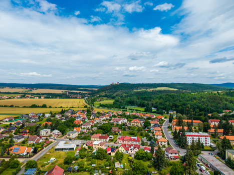 Aerial view of Tocnik Castle overlooking the village with surrounding fields forests and residential houses under a blue sky in Tocnik Stredocesky kraj Czechia. Aerial view of Tocnik Castle overlooking the village with surrounding fields forests and residential houses under a blue sky in Tocnik Stredocesky kraj Czechia.