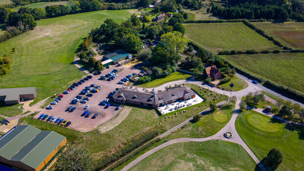 Aerial view of Hamptworth Golf club house with a busy parking lot lush green fairways and surrounding woodland in Hamptworth England United Kingdom. Aerial view of Hamptworth Golf club house with a busy parking lot lush green fairways and surrounding woodland in Hamptworth England United Kingdom.