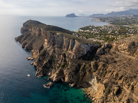 Aerial view of Cala Llebeig with rugged cliffs and turquoise waters along the Mediterranean coastline El Poble Nou de Benitatxell Valencian Community Spain.
