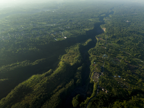 Aerial view of Bunker Kaliadem Merapi and the deep Gendol River valley surrounded by lush tropical forest and morning haze in Kecamatan Pakem Daerah Istimewa Yogya Indonesia. Aerial view of Bunker Kaliadem Merapi and the deep Gendol River valley surrounded by lush tropical forest and morning haze in Kecamatan Pakem Daerah Istimewa Yogya Indonesia.