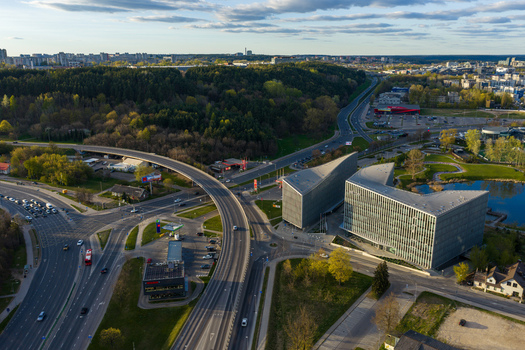 Vilnius County Lithuania 01 May 2026 Aerial view of modern office buildings with glass facades next to a highway overpass and green parkland. Vilnius County Lithuania 01 May 2026 Aerial view of modern office buildings with glass facades next to a highway overpass and green parkland.