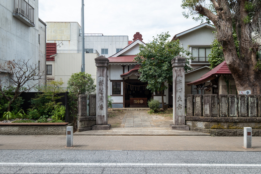 View of an ornate Daishido Temple entrance with stone pillars framing the path amidst aged buildings under a cloudy sky Narita Chiba Japan. View of an ornate Daishido Temple entrance with stone pillars framing the path amidst aged buildings under a cloudy sky Narita Chiba Japan.