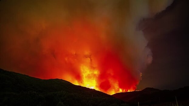 View of a large wildfire burning at night in Spain.
