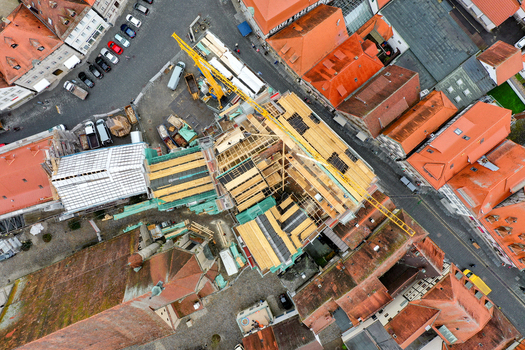 Aerial view of Rathaus Forchheim under renovation with a yellow crane scaffolding and wooden roof structures surrounded by historic red tiled houses in Forchheim Bayern Germany. Aerial view of Rathaus Forchheim under renovation with a yellow crane scaffolding and wooden roof structures surrounded by historic red tiled houses in Forchheim Bayern Germany.