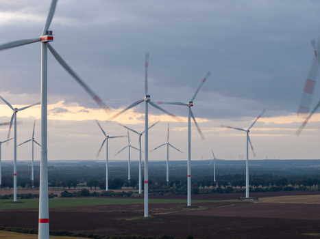 Aerial view of Sieversdorf Windpark with rotating wind turbines set against a cloudy sky over agricultural fields in Jacobsdorf Brandenburg Germany. Aerial view of Sieversdorf Windpark with rotating wind turbines set against a cloudy sky over agricultural fields in Jacobsdorf Brandenburg Germany.